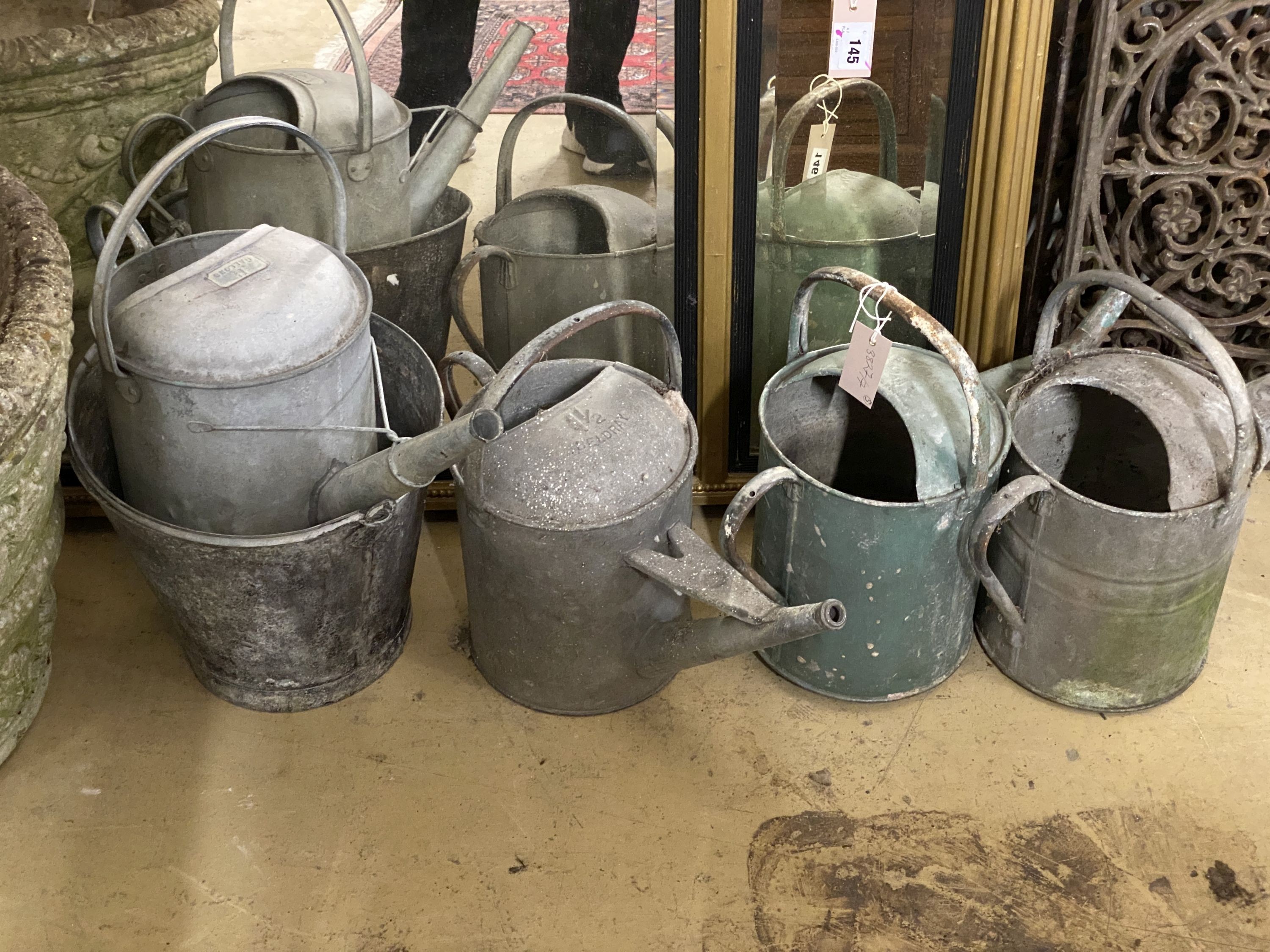 Four galvanised watering cans and a bucket